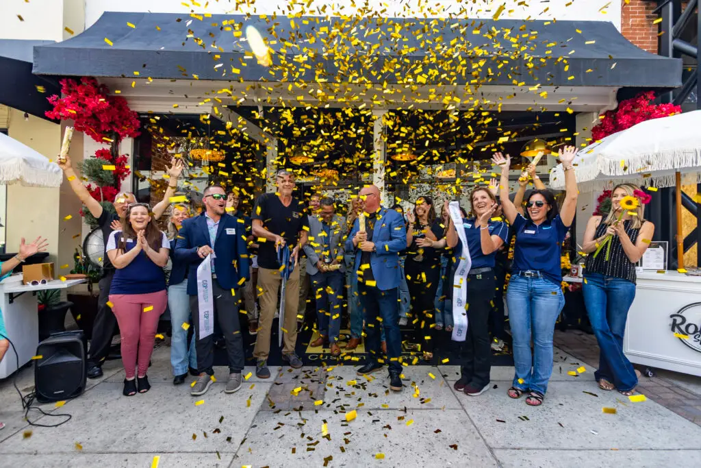 Gold confetti rains down as the Brije Custom Homes team and Ocala Metro CEP cut the ribbon at their downtown Ocala grand opening